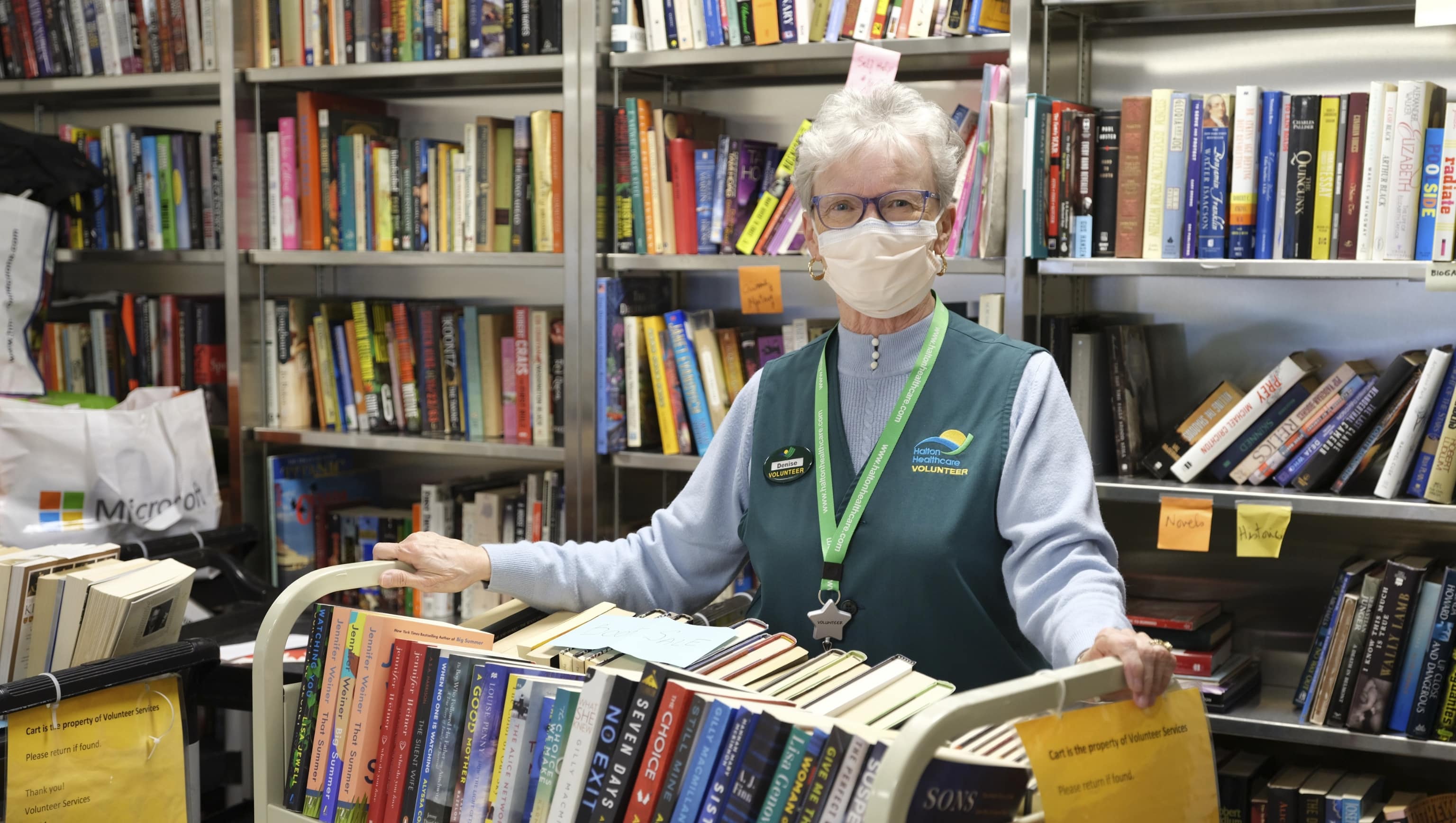 /site_files/content/annual-report/2022/thank-you/thank-you-volunteer-with-books2x.jpg